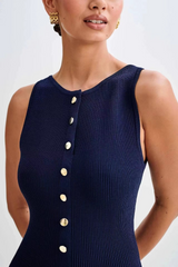 Close-up van navy jurk met gouden knopen en ribstof