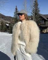 nahaufnahme einer fluffigen beigen kunstpelzjacke mit lockiger struktur