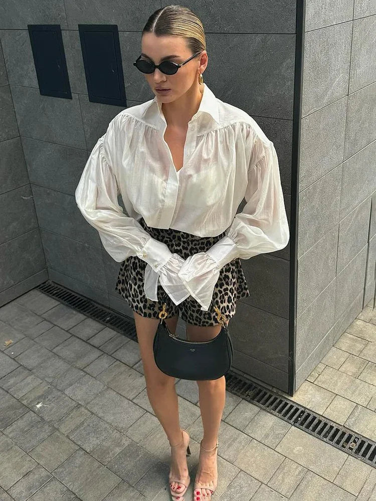 Model draagt een elegante witte blouse gecombineerd met een zwarte rok