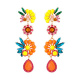 Lange Ohrringe mit tropischen Blüten und funkelnden Steinen
