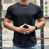 Milan T-shirt in zwart op model met handen gevouwen
