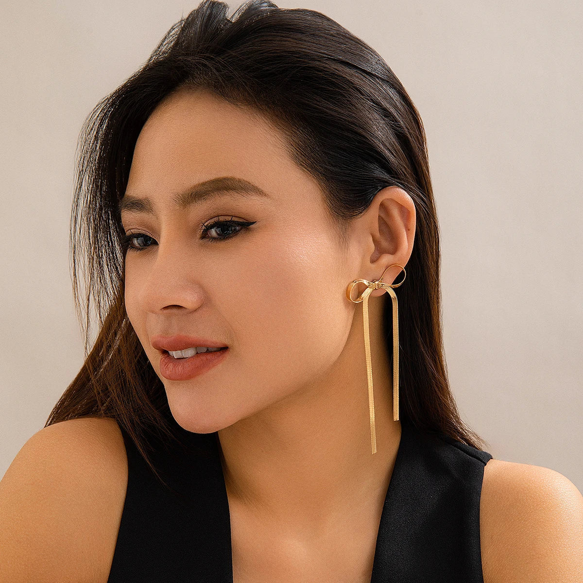 Nahaufnahme Liora Bow Schleifen-Ohrringe in Gold am Ohr
