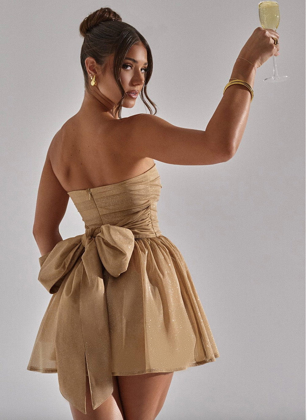 Nuvéra goldenes Glitzerkleid mit Schleife
