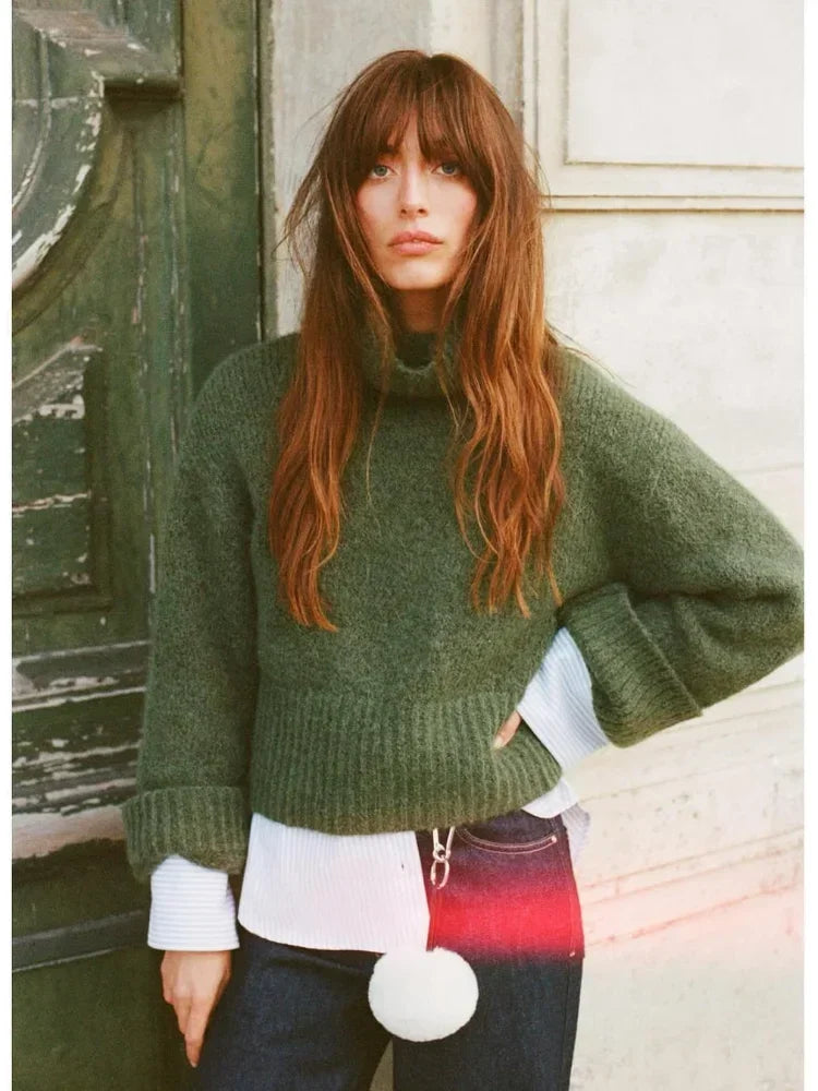 frau kombiniert grünen strickpullover mit rollkragen und weiten ärmeln über bluse