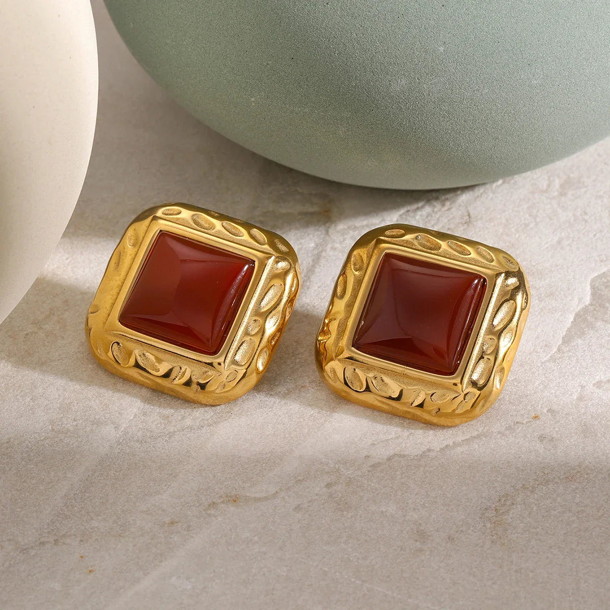 Valoria Carré Ohrringe auf Steinunterlage in Schwarz/Gold
