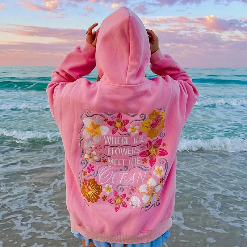 Florina Coast Hoodie Rückseite mit großer Blumenstickerei am Strand
