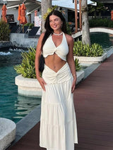 Zomerse tweedelige set bestaande uit een halter crop top en maxi rok, verkrijgbaar in crème en rood, perfect voor strand, festivals en vakanties.