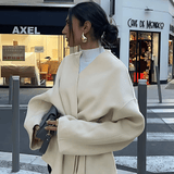 Dalara Mantel in Beige, Seitenansicht abends in der Stadt
