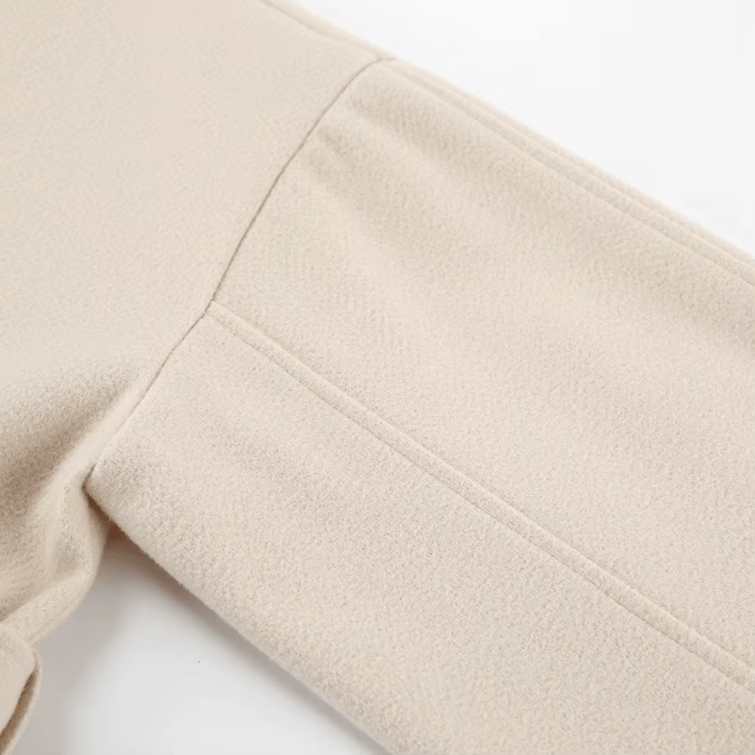 Ärmel- und Nahtdetail des beigen Wickelmantels
