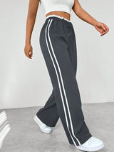 antracietgrijze broek met witte zijlijnen en sportieve uitstraling