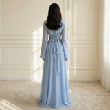 Modell in Elysera Maxikleid Creme mit Rüschen-Detail und langen Trompetenärmeln, Frontansicht