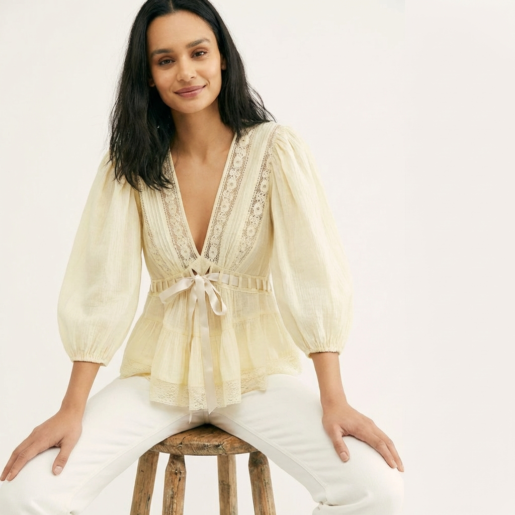 Modell trägt Lunaria Bluse in Gelb mit Spitze, Puffärmeln und Satinband, sitzende Pose