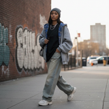 Modell in grauem Rivara Hoodie mit Karo-Detail, Streetstyle-Look auf Stadtstraße mit Graffiti