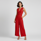Modell trägt Elvara Jumpsuit in Rot mit V-Ausschnitt und Wide-Leg, elegante Frontansicht