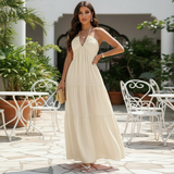 Modell trägt Liora Halter-Maxikleid in Creme mit Korbtasche, Frontansicht im Innenhof