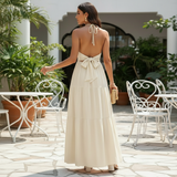 Modell in Liora Halter-Maxikleid Creme – Rückansicht mit Halterband-Schleife
