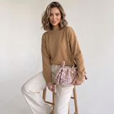 Rosa Faux-Fur-Schultertasche Odette mit Herzdetail am Modell
