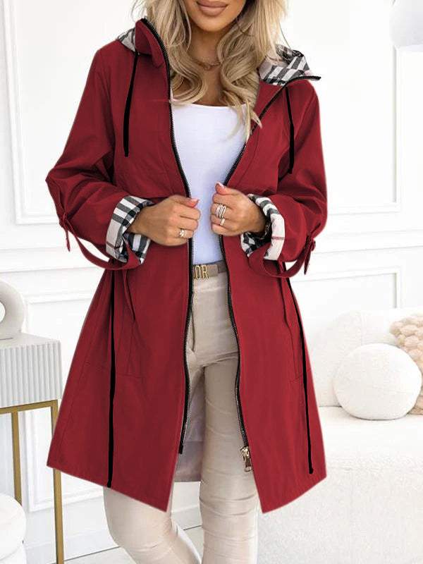 Roter Damen-Trenchcoat mit Kapuze und Karodetail an den Ärmeln.