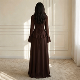 Modell in Elysera Maxikleid Espresso – Detailansicht der Rüschen-Bahn und Trompetenärmel
