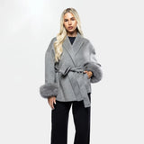 Close-up van Aurora Faux Fur Coat grijs, met strikceintuur en luxe faux fur mouwen
