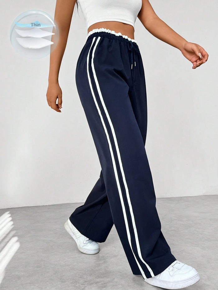 navy blauwe joggingbroek met witte strepen en elastische tailleband