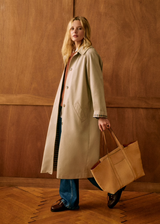 oversized trenchcoat dames, beige trenchcoat met ruitjesvoering, tijdloze trench voor lente en herfst, lange jas dames met knopen, lichte voorjaarsjas met subtiele details, casual chic trenchcoat dames, trendy trench dames met voering, lange jas combineren met jeans, klassieke tussenjas met relaxte fit, gingham voering trenchcoat dames
